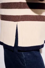 Sweater de punto a rayas horizontales negras y crudas, con cuello redondo y mangas largas. Tiene ribete marrón en puños y ruedo.