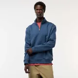 Buzo azul con cuello alto y cremallera parcial.