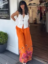 Pantalón palazzo de lino color celeste con cintura elastizada y estampado floral en el ruedo.