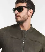 Chaqueta bomber azul marino lisa, con cierre frontal, cuello redondo y bolsillos laterales.