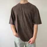 Remera oversize gris con efecto lavado, de manga corta y cuello redondo. Presenta un gran diseño bordado en la espalda con el contorno de una estrella y letras superpuestas.