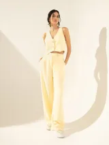 Pantalón negro de crepe con cintura cruzada, broche con brillo glitter, tiro alto, pinzado y pata ancha.