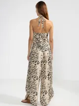Pantalón de lino italiano con estampa combinada de animal print tipo leopardo y cebra en tonos crema y negro. Presenta corte recto, talle medio y bolsillos delanteros.