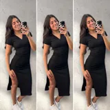 Vestido midi negro ajustado al cuerpo, con cuello tipo polo, mangas cortas y tajo lateral.
