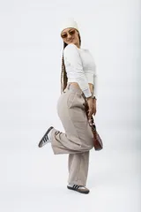 Pantalón de corte sastrero y tiro bajo, con diseño de pierna ancha y holgada. Presenta cierre frontal con botón y bolsillos laterales.