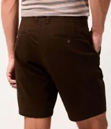 Bermuda masculina slim confeccionada en sarga de algodón con elastano, color beige, con bolsillos laterales tipo chino, bolsillos traseros embutidos con botón, trabillas en la cintura y cierre frontal con botón y cremallera.