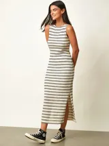 Vestido midi de punto a rayas horizontales negras sobre fondo blanco, con cuello redondo, sin mangas y tajo lateral en el dobladillo.