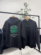 Canguro oversize negro con capucha y bolsillo tipo canguro frontal. Presenta un gran estampado en la espalda con la leyenda "Good Vibes Positive Energy Streetwear Apparel" en tonos verdes y blancos.