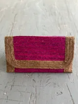 Sobre de mano rectangular, tejido en fibras naturales color fucsia y beige.