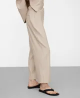 Pantalón de pierna recta y largo tobillero, color beige con diseño microdibujo. Cuenta con cinturilla elástica en los costados, bolsillos laterales y un bolsillo de vivo con botón en la espalda.