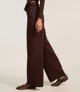 Pantalón wide leg color crudo confeccionado en sarga con pespuntes contrastantes, cintura alta con trabillas, cierre por botón y cremallera, bolsillos delanteros y traseros.