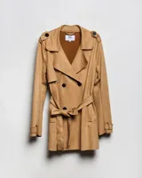 Campera tipo trench de color habano, de corte a la cadera, confeccionada en material textil símil gamuza. Presenta solapa cruzada, doble botonadura frontal, hombreras y cinturón ajustable para anudar en la cintura. Incluye bolsillos delanteros y puños con trabilla.