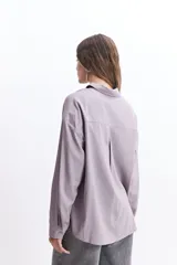 Camisa oversize color crema con detalles de puntilla roja en el frente.