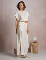Blusa corta de lino marca Elan, de corte crop con silueta holgada, hombros caídos, escote amplio a la base y aberturas laterales ajustables con lazos para anudar.