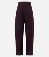 Pantalón de sastrería corte barrel, color marrón oscuro, con pliegues delanteros, cintura con cierre desplazado y piernas anchas.