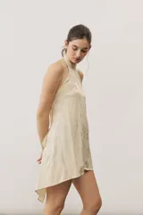 Top halter celeste con diseño asimétrico de corte más largo en la parte trasera, cuello alto y sutil estampado floral.