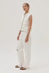 Pantalón de jean blanco, de calce recto y tiro medio-alto. Cuenta con un corte en la rodilla y ruedo desflecado.