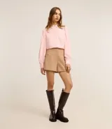 Camisa celeste de crepé con cuello inglés, manga larga abullonada y abotonadura frontal.