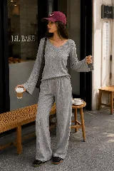 Remera de lanilla gris con textura acanalada, escote en V y mangas largas estilo oxford. Presenta un corte holgado y cómodo.