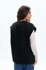 Chaleco de punto color negro, con escote en V y diseño holgado.
