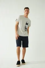 Remera de manga corta color gris claro con cuello redondo y estampado de tres fotos en blanco y negro en el frente.