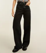 Pantalón wide leg de jean negro, tiro alto, con bolsillos delanteros y traseros, presillas en la cintura y cierre frontal con botón y cremallera.