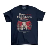 Remera azul marino de manga corta, con estampa frontal alusiva a la banda Foo Fighters y su presentación en Montevideo, mostrando un diseño de OVNIs y un carpincho tomando mate.
