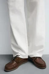 Mocasín náutico de cuero marrón, con cordones de cuero, ojales metálicos y detalles en gamuza a tono.