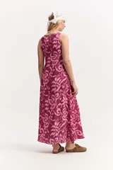 Vestido largo sin mangas, con escote redondo y silueta amplia. Presenta un estampado abstracto en tonos fucsia y rosado.