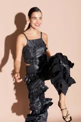 Top negro brillante con tirantes finos y volados en el frente.