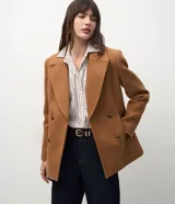 Blazer de paño color tostado, de doble botonadura, con solapas de muesca y bolsillos laterales ribeteados.