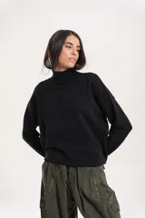 Polera de lana de corte holgado, con cuello alto tejido y mangas largas con caída de hombro.