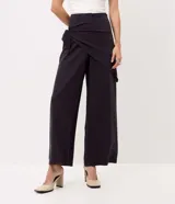 Pantalón wide leg negro de viscosa, con piernas amplias, caída fluida y detalle de pañuelo cruzado con atadura lateral en la cintura.