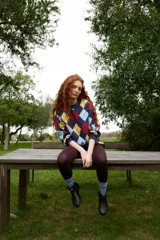 Buzo de tejido de punto con diseño de rombos en colores azul marino, amarillo, celeste y rojo. Presenta cuello redondo a la base, corte oversized y puños acanalados.
