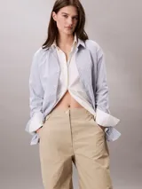 Pantalón parachute color beige de nailon arrugado, corte holgado, cintura elástica con cordón interior, puños con cordón y cremallera, cierre mediante botón y cremallera, diseño de bolsillo superpuesto y bordado de Calvin Klein en la cadera.