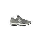 Championes New Balance modelo 2002R en color gris con detalles en blanco y negro, confeccionados con malla transpirable y paneles de gamuza. Incorporan la tecnología N-ERGY en la suela para mayor amortiguación y el logotipo "N" característico en los laterales.