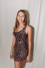 Vestido dorado ajustado al cuerpo, con un solo hombro y largo a la rodilla.