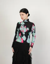 Polera de cuello alto y mangas largas, confeccionada en tela sublimada con estampado abstracto en tonos negro, verde, azul y rosa.
