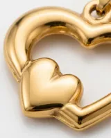 Dije de acero con baño dorado, compuesto por dos corazones concéntricos de diseño minimalista.
