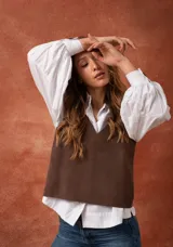 Chaleco marrón de cuero con escote en V y espalda cruzada.