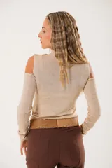 Polera beige de cuello alto con mangas largas y abertura en el pecho.