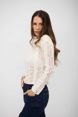 Top de encaje blanco con diseño de rayas verticales, manga larga y cuello redondo.