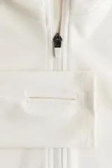 Campera deportiva de corte ajustado confeccionada en tejido funcional SoftMove y DryMove. Presenta capucha, cierre frontal con protección para el mentón, bolsillos laterales con cierre y mangas extralargas con abertura para el pulgar.