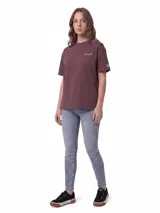Remera Caterpillar de corte boxy, color marrón oscuro, con cuello redondo y mangas cortas. Presenta un delicado bordado con el logotipo de la marca en el pecho y un parche tejido en la manga.