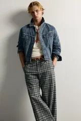Pantalón flare fit confeccionado en tejido con algodón, con estampado a cuadros en tonos grises y negros. Cuenta con bolsillos laterales, bolsillos traseros de vivo y cierre frontal con cremallera y botón.