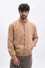 Campera estilo bomber de hombre, color tostado, con cierre frontal metálico, cuello y puños acanalados.