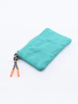 Monedero rectangular de color fucsia con diseño acolchado de costuras en zigzag. Cuenta con cierre superior y un tirador de cordón trenzado multicolor con punteras naranjas.