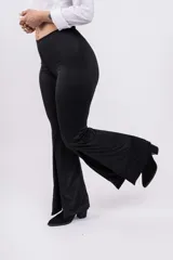 Calza negra de tiro alto, corte ajustado en la parte superior y acampanado en la parte inferior, con aberturas laterales en el ruedo.