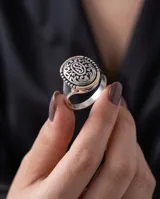 Anillo de plata y oro de diseño ovalado, con detalles grabados y filigrana en relieve en la parte superior.