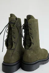 Botas de caña media color marrón, con cordones en la parte trasera y cierre lateral con cremallera.